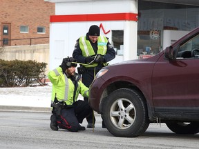 Members of the Greater Sudbury Police Services traffic management unit take measurements where a pedestrian was struck by a vehicle in Sudbury, Ont. on Monday December 28, 2015. Gino Donato/Sudbury Star/Postmedia Network