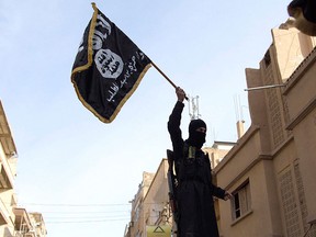 A member of an Islamist group holds a flag during a protest in Deir el-Zor in this Feb. 25, 2013 file photo.  REUTERS/Khalil Ashawi