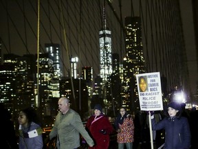 People march through Brooklyn Bridge as they take part in a protest against the police in Manhattan, New York, December 28, 2015 after a grand jury cleared two Cleveland police officers on Monday in the November 2014 fatal shooting of 12-year-old Tamir Rice. (REUTERS/Eduardo Munoz)