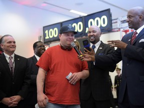 Passenger Larry Kendrick, middle, speaks next to Hartsfield-Jackson Atlanta International Airport Manager Miguel Southwell, right, during a ceremony naming Kendrick the airport's 100 millionth passenger on Sunday, Dec. 27, 2015, in Atlanta. The airport that calls itself the world's busiest announced on its social media sites said it served its 100 millionth passenger this year. (Kent D. Johnson/Atlanta Journal-Constitution via AP)