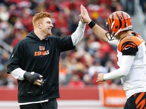 Injured Cincinnati Bengals quarterback Andy Dalton, left, celebrates with quarterback AJ McCarron after the team scored a touchdown against the San Francisco 49ers during a game in Santa Clara on Dec. 20, 2015. (AP Photo/Tony Avelar)