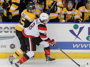 Ottawa 67's Ben Fanjoy checks Kingston Frontenacs Sam Field in front of the home teams bench to take control of the puck during the first period of Ontario Hockey League action at the Rogers K-Rock Centre in Kingston, Ont. on Tuesday, December 29, 2015. JULIA MCKAY/Whig-Standard/QMI Agency