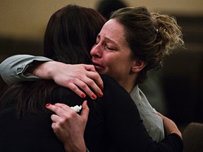 Sara Chaloux, a friend of the deceased, embraces another mourner during a viewing of the body of Ricky Cenabre at Serenity Funeral Service in Edmonton, Alta., on Tuesday, Dec. 29, 2015. Cenabre was one of two Mac's workers gunned down in a robbery on Dec. 18. Codie McLachlan/Edmonton Sun/Postmedia Network