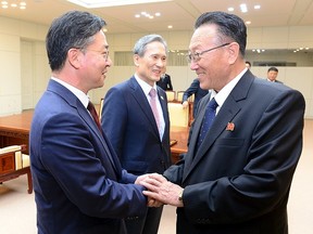 South Korean Unification Minister Hong Yong-pyo, left, shakes hands with Secretary of the Central Committee of the Workers' Party of Korea Kim Yang Gon after the inter-Korean high-level talks at the truce village of Panmunjom inside the Demilitarized Zone separating the two Koreas, South Korea, in this picture provided by the Unification Ministry and released by Yonhap on August 25, 2015. (REUTERS/the Unification Ministry/Yonhap)