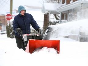 Richard d'Entremont clears his driveway with a snow blower in Sudbury, Ont. on Tuesday December 29, 2015. Greater Sudbury received about 30 centimetres of snow. Gino Donato/Sudbury Star/Postmedia Network