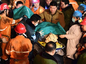 In this Dec. 25, 2015 photo released by China's Xinhua News Agency, a trapped miner is rescued from a collapsed gypsum mine in Pingyi County, east China's Shandong Province. Chinese rescuers pulled more than 10 workers to safety and located another workers who were trapped after a mine collapsed in the eastern province of Shandong, state media said Saturday. (Guo Xulei/Xinhua via AP)