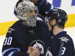 Winnipeg Jets goalie Connor Hellebuyck (l) is congratulated by defenceman Jacob Trouba after defeating the Detroit Red Wings 4-1 during NHL hockey in Winnipeg, Man. Tuesday December 29, 2015.
Brian Donogh/Winnipeg Sun/Postmedia Network