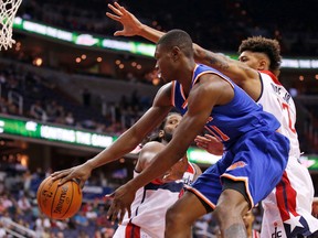 New York Knicks forward Cleanthony Early (11) passes in front of Washington Wizards forward Nene, left, and forward Kelly Oubre Jr. in the first half of an NBA preseason basketball game, Friday, Oct. 9, 2015, in Washington. (AP Photo/Alex Brandon)