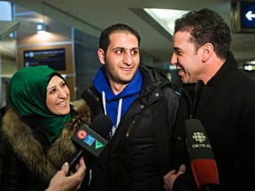 Rima Tomeh, left, and Anwar Shamseddin, right, greet Rima's brother, Moaed Tomeh, a Syrian refugee, at the Edmonton International Airport in Edmonton, Alta., on Monday, Dec. 28, 2015. Codie McLachlan/Edmonton Sun