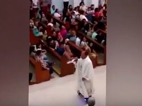In this YouTube video still, Rev. Albert San Jose is seen riding a hoverboard and singing a song during Christmas Eve Mass in the Philippines. (YouTube/Screengrab)