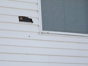A bullet hole is clearly visible from 199 Street in the side of a house at Graham Wynd where a woman was shot while asleep in her bed in an apparent random act on Sunday, Dec. 27, 2015. CLAIRE THEOBALD Edmonton Sun