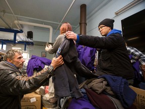 Volunteers hands out warm clothing to people in need at Boyle Street Community Services during Hoodies for the Homeless in Edmonton, Alta., on Saturday, Dec. 6, 2014. The charity is in Lee's brother Craig's memory. One thousand pieces of warm clothes were handed out by volunteers on Saturday. Ian Kucerak/Edmonton Sun