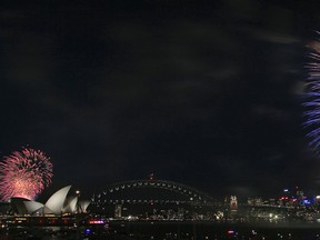 Fireworks explode over the Opera House and Harbour Bridge during the fireworks display in Sydney, Australia, on Dec. 31, 2015. (AP Photo/Rob Griffith)