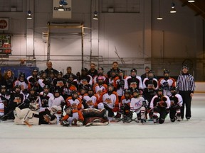 Members of the Winnipeg Storm A2 Peewee Orange and the Winnipeg Storm Peewee A2 Black, along with some other guests, had a charity hockey game on Dec. 23, 2015, at River Heights Arena. More than $650 was raised for the Christmas Cheer Board. (SUPPLIED PHOTO)