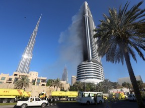 Plumes of smoke rise from the 63-storey Address Downtown Dubai hotel and residential block near the Burj Khalifa, the tallest building in the world, a day after the hotel caught fire on New Year's Eve, in Dubai, on Jan. 1, 2016. (REUTERS/Stringer)