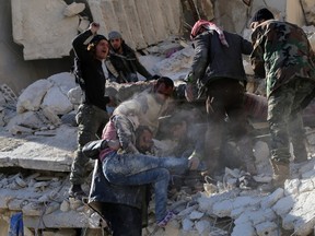 Syrian civilians and rebel fighters remove a girl and search for other victims in the rubble of a building following a reported air strike by Syrian government forces in Syria’s northern city of Aleppo in December. (BARAA AL-HALABI/AFP Photo)