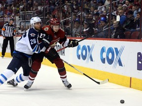Dec 31, 2015; Glendale, AZ, USA; Arizona Coyotes defenseman Oliver Ekman-Larsson (23) and Winnipeg Jets right wing Blake Wheeler (26) battle for a puck during the third period at Gila River Arena. The Coyotes won 4-2. Mandatory Credit: Joe Camporeale-USA TODAY Sports