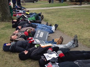 In this photo provided by cleveland.com, protesters lie down on the ground near the home of Cuyahoga County Prosecutor Tim McGinty in Cleveland on Friday, Jan. 1, 2016. Protesters upset by a decision not to indict two white police officers in the shooting death of Tamir Rice, a 12-year-old black boy who had a pellet gun, marched to the home of the Cleveland prosecutor on Friday and repeated calls for him to resign. (Jane Morice/cleveland.com via AP)