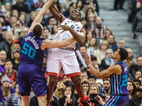 Raptors forward Bismack Biyombo battles for a rebound with Charlotte Hornets’ Tyler Hansbrough during Friday night’s game. (ERNEST DOROSZUK/Toronto Sun)