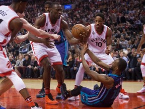 Toronto Raptors' Bismack Biyombo, centre, claims a loose ball under the hoop in front of Charlotte Hornets' Kemba Walker, as Raptors' Terrence Ross and DeMar DeRozan look on, during second half NBA basketball action in Toronto on Friday January 1, 2016. (THE CANADIAN PRESS/Chris Young)