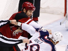Arizona Coyotes' John Scott, left, punches Columbus Blue Jackets' Jared Boll during a fight on Dec. 17, 2015, in Glendale, Ariz. (AP Photo/Ross D. Franklin)