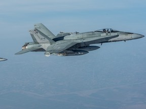 Two CF-18 Hornets prepare to resume their activities after being refuelled by a CC-150 Polaris during Operation IMPACT on February 4, 2015. Photo: Canadian Forces Combat Camera, DND