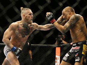 Conor McGregor, left, and Dustin Poirier, exchange hits during their fight in Las Vegas in 2014.  (AP Photo/John Locher,File)