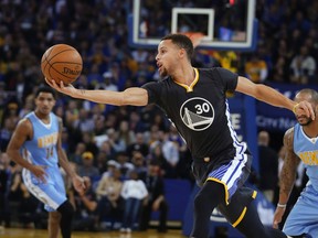 Golden State Warriors' Stephen Curry grabs a rebound during the first half of an NBA basketball game against the Denver Nuggets on Saturday, Jan. 2, 2016, in Oakland, Calif. (AP Photo/Marcio Jose Sanchez)