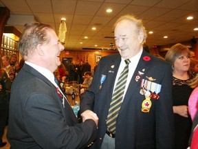 Oxford County Naval Veterans Association (OCNVA) president Bryan Bucholtz, left, greets former Canadian Amry Corporal Gary Dassy when the OCNVA hosted its annual Levee Day on Friday, Jan. 1. The club was packed with people socializing, eating and wishing each other "Happy New Year." JOHN TAPLEY/SENTINEL-REVIEW