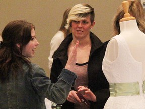 Bride-to-be Devon Beach listens as Hannah Connors of Altered Elegance talks about the alterations services the Petrolia shop offers. They were at the annual Bridal Odyssey show at the Lambton College event centre Sunday. (Tyler Kula/Sarnia Observer/Postmedia Network)