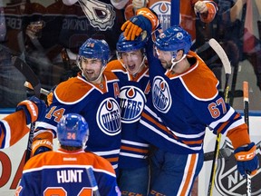 Edmonton Oilers' Brad Hunt (24), Jordan Eberle (14), Ryan Nugent-Hopkins (93) and Benoit Pouliot (67) celebrate a goal against the Arizona Coyotes during third period NHL action in Edmonton, Alta., on Saturday January 2, 2016. THE CANADIAN PRESS/Jason Franson