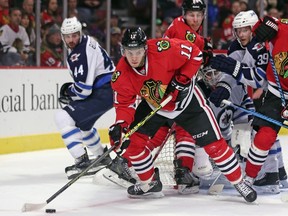 Jeremy Morin #11 of the Chicago Blackhawks tries to pass the puck near the net against the Winnipeg Jets at the United Center on November 2, 2014 in Chicago, Illinois. The Jets defeated the Blackhawks 1-0.   Jonathan Daniel/Getty Images/AFP