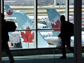 Passengers walk past Air Canada planes on the runway at Pearson International Airport in Toronto in this April 13, 2012, file photo.  REUTERS/Mike Cassese/Files