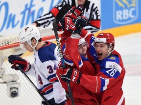 Russia's Pavel Kraskovski, middle, celebrates his second period goal with teammate Yegor Korshkov as United States' Auston Matthews skates past during semifinal hockey action at the IIHF World Junior Championship in Helsinki, Finland on Monday, Jan 4, 2016. THE CANADIAN PRESS/Sean Kilpatrick