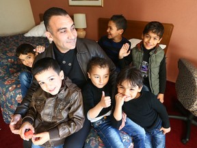 Syrian refugee Eyed Tebawi with his sons at the Toronto Plaza Hotel in Toronto on Monday, January 4, 2016. (Dave Abel/Toronto Sun)