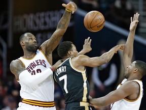 Cavaliers' LeBron James (left) and Tristan Thompson (right) put pressure on Raptors' Kyle Lowry during first half NBA action in Cleveland on Monday, Jan. 4, 2016. (Tony Dejak/AP Photo)