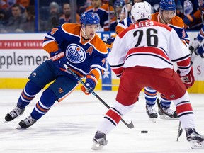 The Edmonton Oilers' Taylor Hall (4) battles the Carolina Hurricanes John-Michael Liles (26) during first period NHL action at Rexall Place, in Edmonton Alta. on Monday Jan. 4, 2016. David Bloom/Edmonton Sun/Postmedia Network