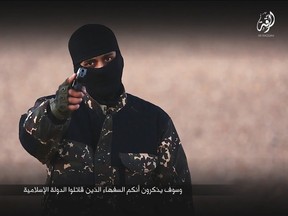 A masked man points a weapon as he speaks in this still image from a handout video obtained on Jan. 4, 2016, from a social media website which has not been independently verified. Britain was on Monday examining the Islamic State video showing a young boy in military fatigues and an older masked militant who both spoke with British accents. The propaganda video, which could not be independently verified, also shows the killing of five men accused of spying for the West. (REUTERS/Social Media via Reuters)