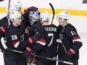 Goalkeeper Alex Nedeljkovic of the U.S, center, is congratulated by teammates after their victory in the 2016 IIHF World Junior Ice Hockey Championship bronze medal game between Sweden and the USA in Helsinki, Finland, Tuesday, Jan. 5, 2016. (Markku Ulander/Lehtikuva via AP)