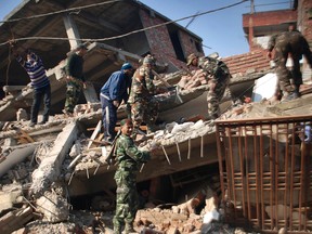 Indian soldiers and locals remove debris from a damaged building after an earthquake in Imphal, capital of the northeastern Indian state of Manipur, Monday, Jan. 4, 2016.  (AP Photo/Bullu Raj)