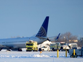 Emergency vehicles surround a United Airlines aircraft as passengers wait to be evacuated, Tuesday, Jan. 5, 2016, at the Spokane International Airport in Spokane, Wash. (Jesse Tinsley/The Spokesman-Review via AP)