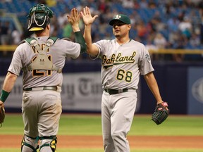 Oakland Athletics relief pitcher Arnold Leon (68) is congratulated by catcher Stephen Vogt (21) after they beat the Tampa Bay Rays at Tropicana Field. Oakland Athletics defeated the Tampa Bay Rays 7-2. Kim Klement-USA TODAY Sports