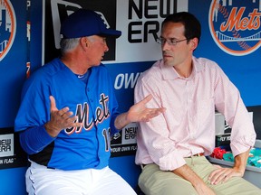 In this Aug. 8, 2011, file photo, New York Mets manager Terry Collins talks with VP of Player Development Paul DePodesta (right) in the dugout before a game against the San Diego Padres in New York. (AP Photo/Paul J. Bereswill, File)