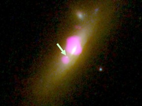 This image provided by CU-Boulder shows the galaxy SDSS J1126+2944 taken with the Hubble Space Telescope and the Chandra X-ray Observatory, with an arrow placed by the source pointing to a black hole that lost most of its stars. (NASA/CU-Boulder via AP)