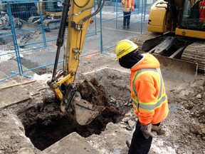A worker watches an excavator dig into Princess Street between Bagot and Montreal streets on Tuesday as the third phase of the Big Dig begins. (Elliot Ferguson/The Whig-Standard)