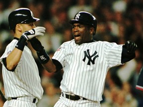 New York Yankees' hitter Tim Raines (R) celebrates his sixth-inning, three-run home run at home with teammate Derek Jeter in the game against the Cleveland Indians in the American League Divison Series, Sept. 30 at Yankee Stadium. (REUTERS)