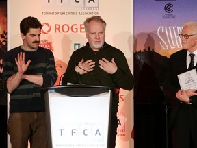Toronto Film Critics Association president Brian Johnson looks on from the right as Co-directors of The Forbidden Room, Evan Johnson and Guy Maddin, right, accept the $100,000 award for best Canadian Film during the The 2015 Toronto Film Critics Association Awards in Toronto on Tuesday, January 5, 2016. THE CANADIAN PRESS/Cole Burston