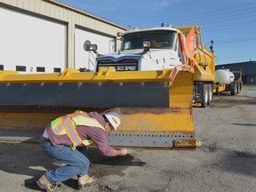 A Carillion snow plow driver examines a plow. (IAN MCINROY/Postmedia Network files)
