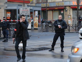 Police officers secure a perimeter near the scene of a fatal shooting which took place at a police station in Paris, on Jan. 7, 2016. (AP Photo/Christophe Ena)