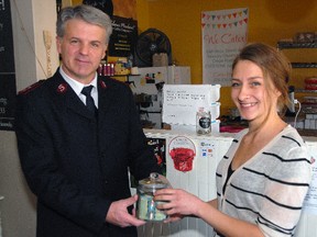 Salvation Army St. Thomas Capt. Mark Hall, left, accepts a $140 donation from That Crepe Place owner Helena Fehr. The local business collected donations for the Salvation Army's 2015 kettle campaign. The annual initiative surpassed it's $145,000 goal, raising $146,055.85 throughout November and December.